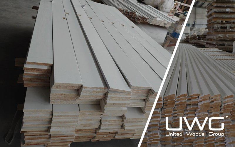 Primed wooden door components stacked in a factory workshop