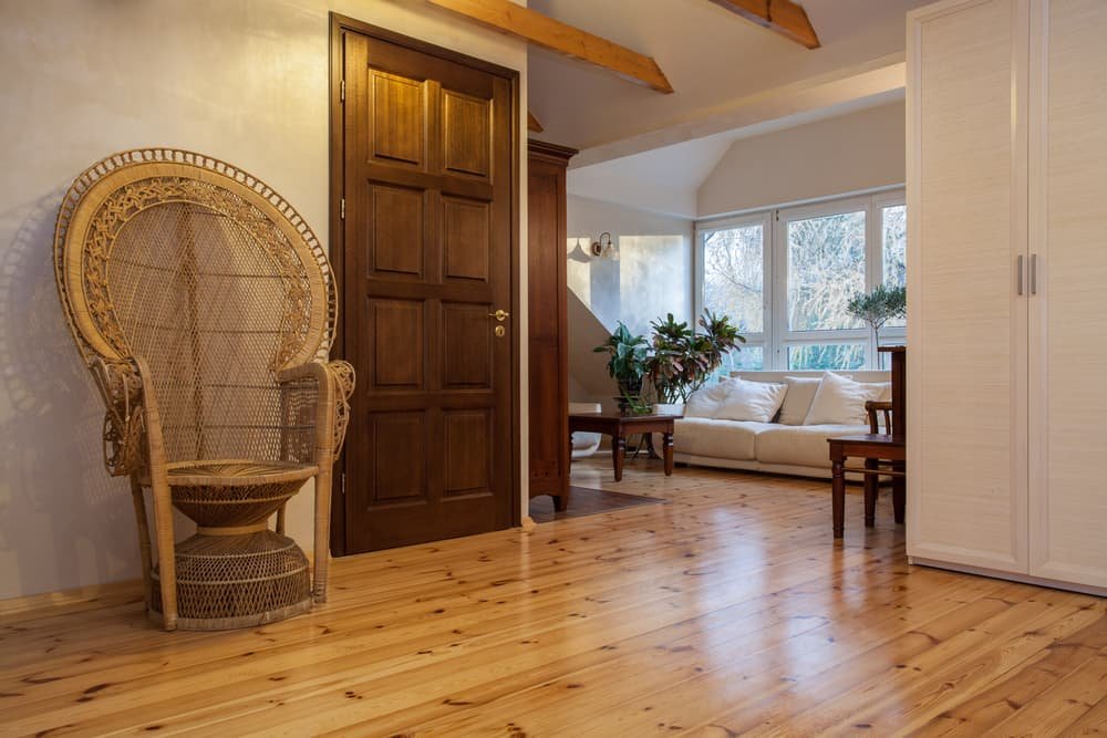 Solid wood interior door with natural wood flooring in a warm, rustic living space